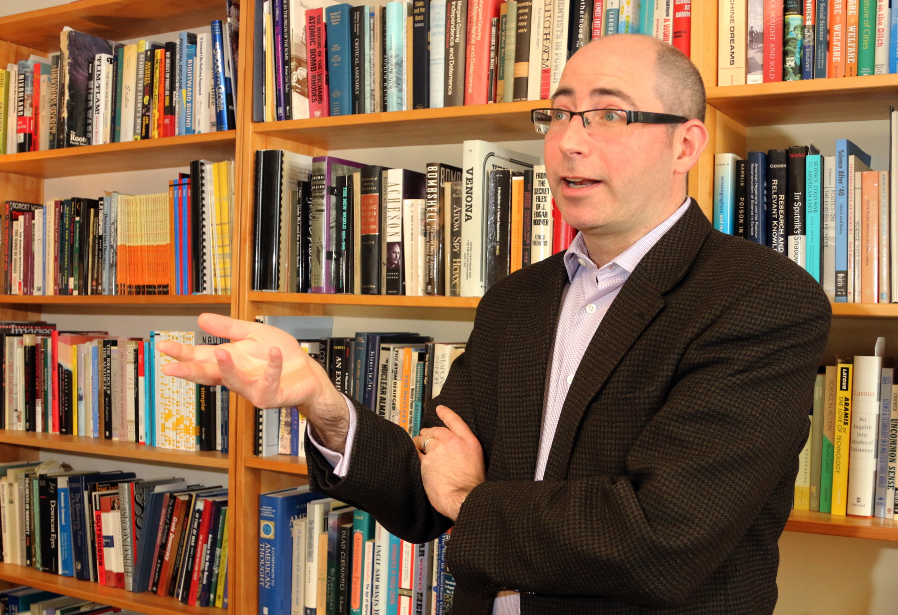 David Kaiser stands in front of a shelf of books