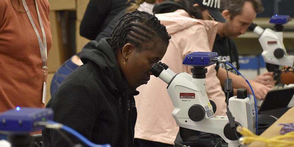 Sharon Muzaki, Africa and Middle East Fellow, uses a microscope